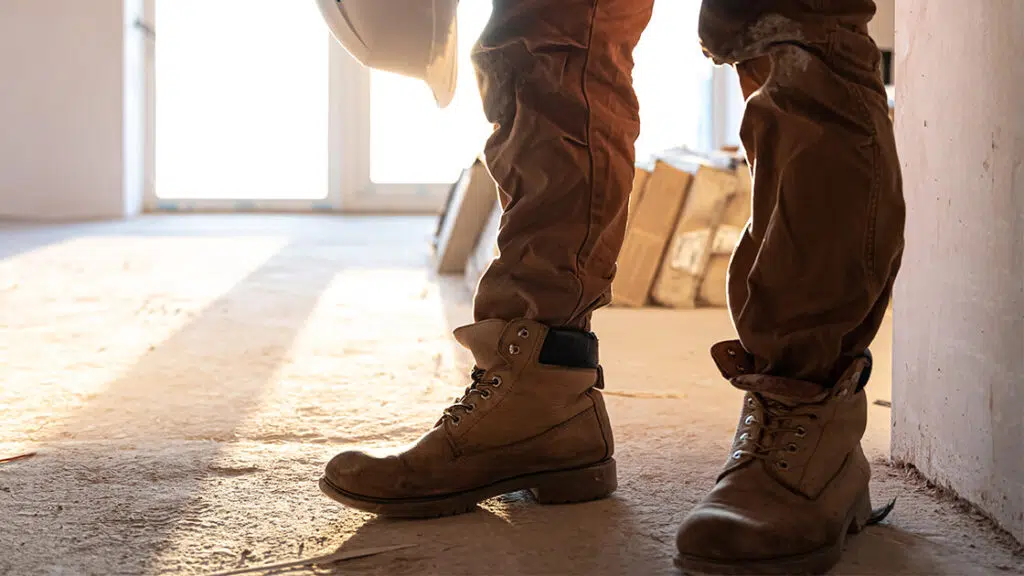 hombre usando zapatos de seguridad en una casa en construcción